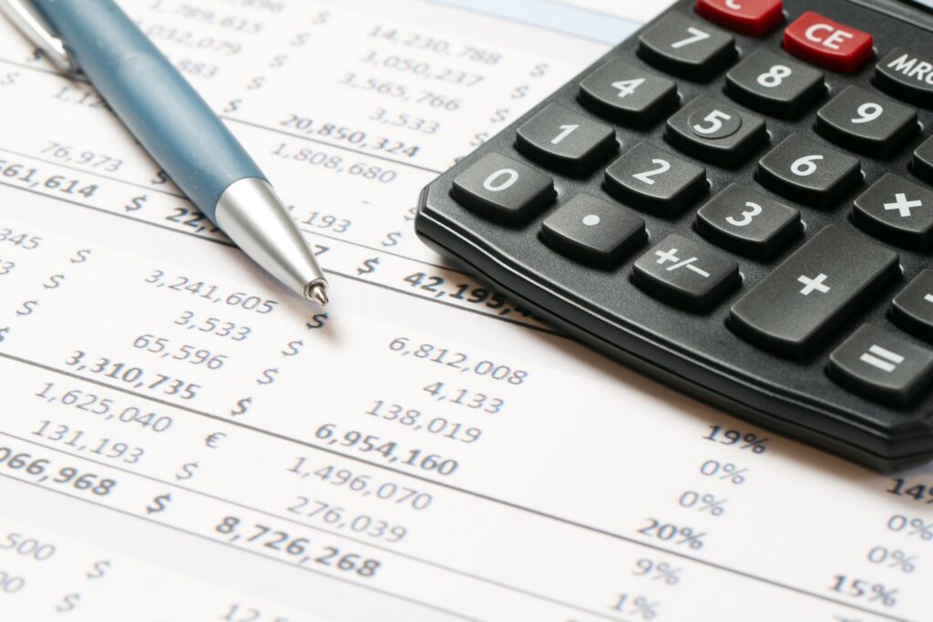 Financial statement or balance sheet summary report with calculator and pen